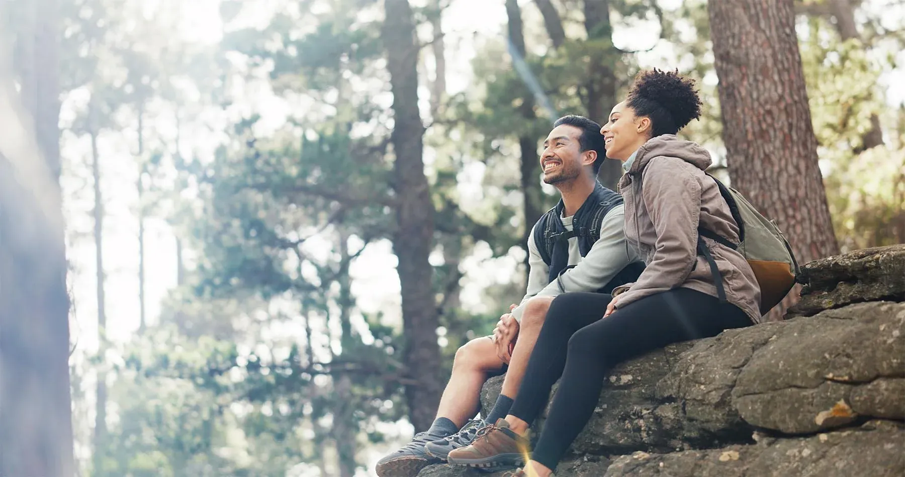 Two people taking a break together on a wooded trail